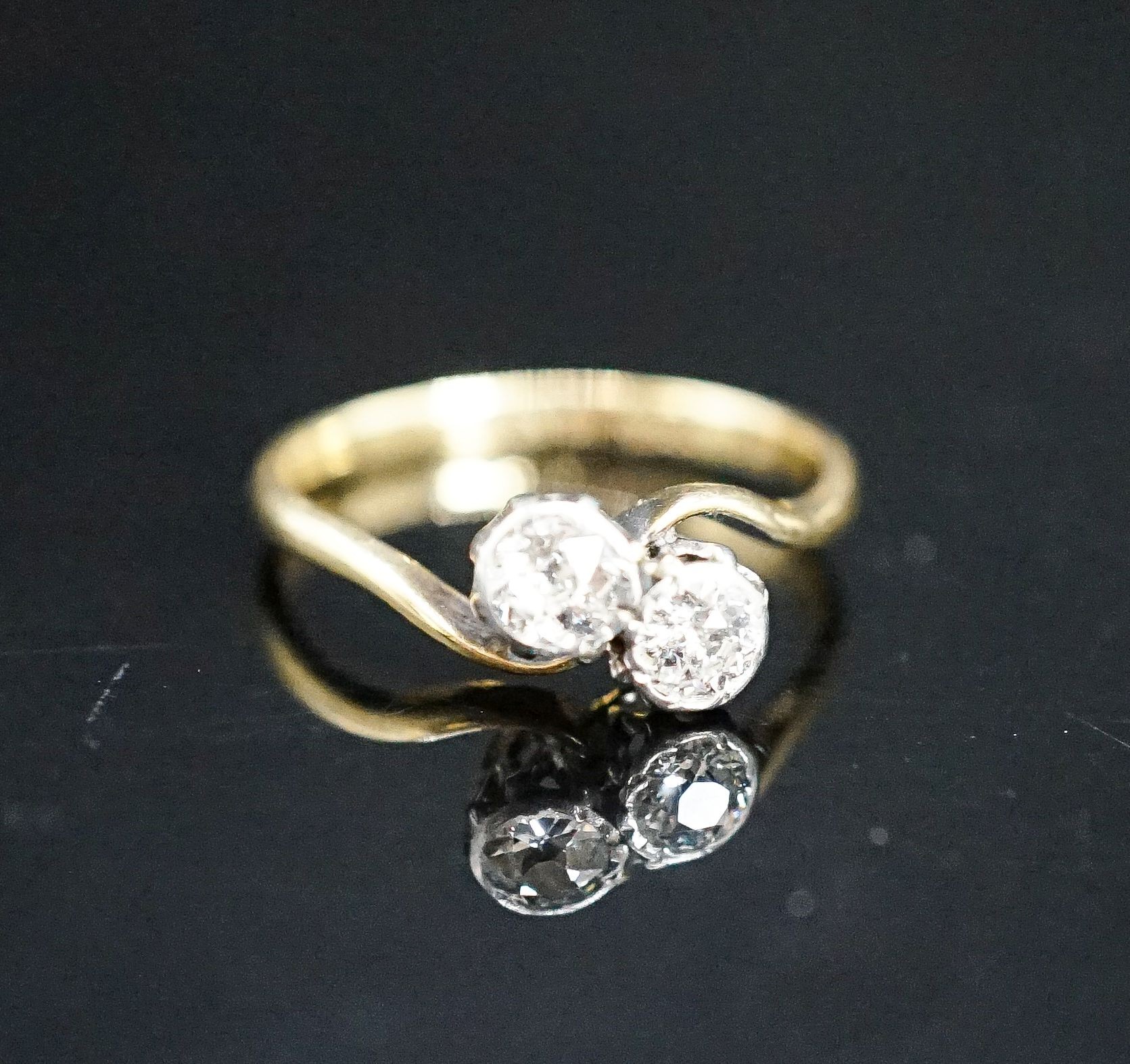 An 18ct & plat, two stone diamond crossover ring, size J, gross weight 1.8 grams.